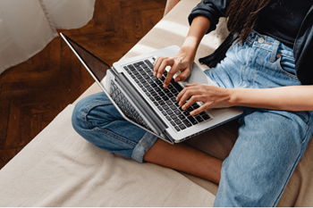 a woman sitting on a couch using a laptop computer